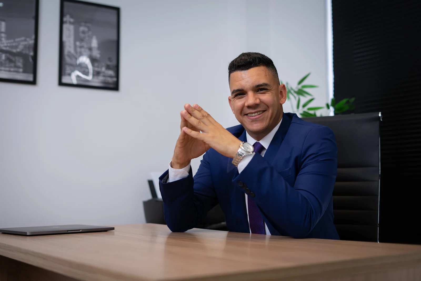 Helder Nangino sorrindo à mesa de atendimento